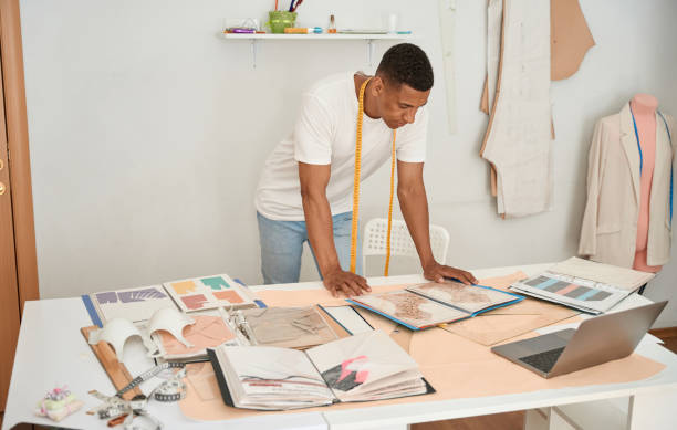 istock Young tailor working with drawings and laptop 1410874083