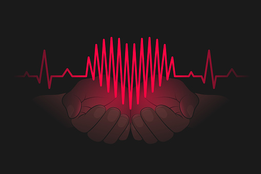 Heartbeat chart shaped like heart symbol on open palms in the dark, hands are carefully holding heart. Care for cardiovascular system, health, wellness, healthy lifestyle, falling in love concept