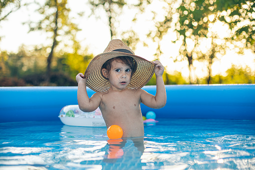 Portrait cute small girl wearing a sun hat in the pool