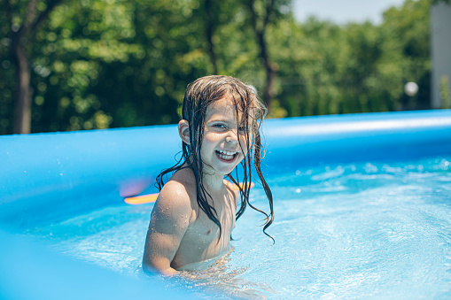 Portrait of cute girl playing in the pool