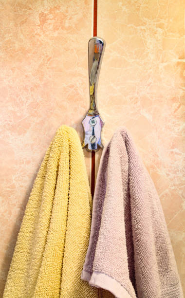 istock Two cotton towels hanging on bathroom hook. Close up 1410878277