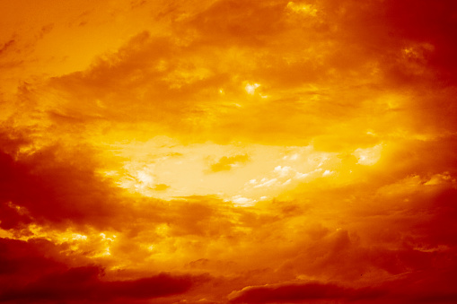 Red yellow orange sky with clouds view. Dramatic skies background with space for design. Dark gloomy storm clouds. Lightning fire bright flash explosion in the sky. Armageddon, horror, scary, creepy