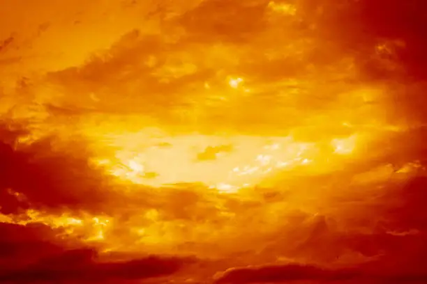 Photo of Red yellow orange sky with clouds view. Dramatic skies background with space for design. Dark gloomy storm clouds.