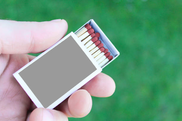 Person holding box of matches on 
green background. Person holding box of matches on 
green background. matchbox stock pictures, royalty-free photos & images