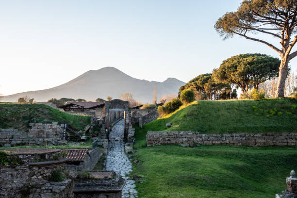 Early morning, a road leading to the ancient city remains of Pompeii, Mount Vesuvius in the background, Italy Early morning, a road leading to the ancient city remains of Pompeii, Mount Vesuvius in the background, Southern Italy pompeii ruins stock pictures, royalty-free photos & images