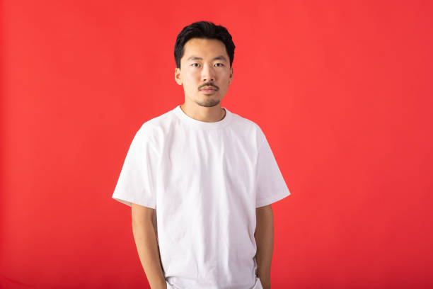East Asian model going for portraits photos in studio. In this photo, he is standing with confidence and looking at camera.