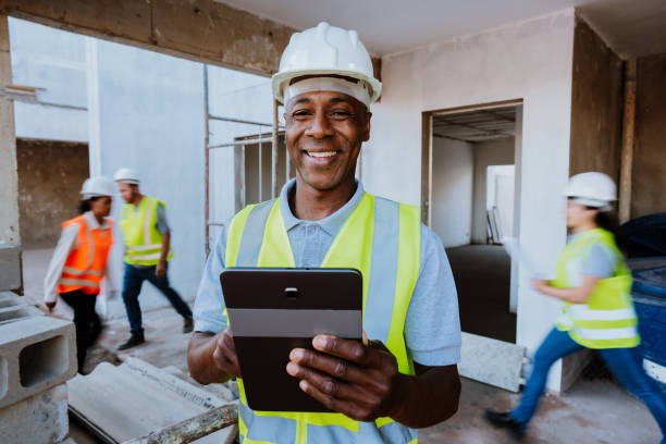 man at construction site holding digital tablet - building contractor engineer digital tablet construction imagens e fotografias de stock