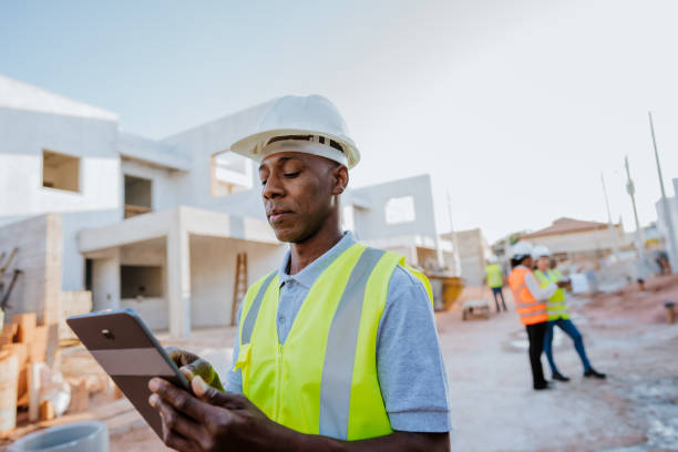 man at construction site holding digital tablet - building contractor engineer digital tablet construction imagens e fotografias de stock