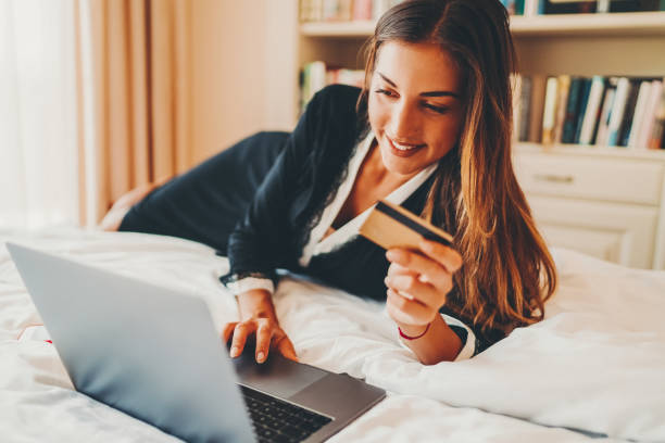 istock Woman in bed shopping online 1410884321