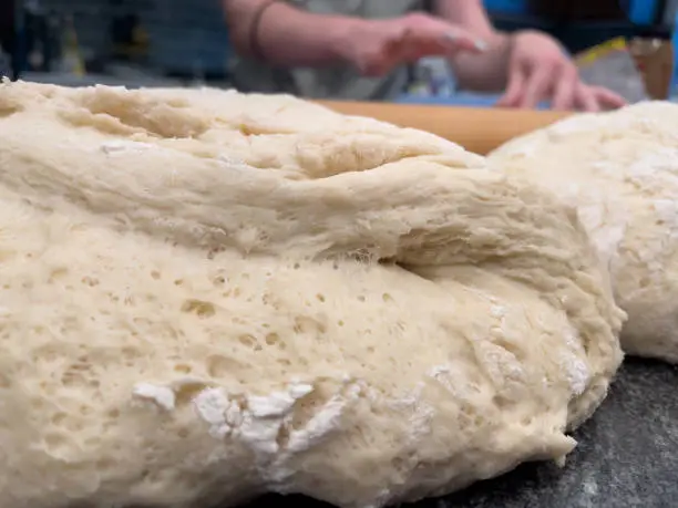 large lump of white bread dough with flour and air pockets on it