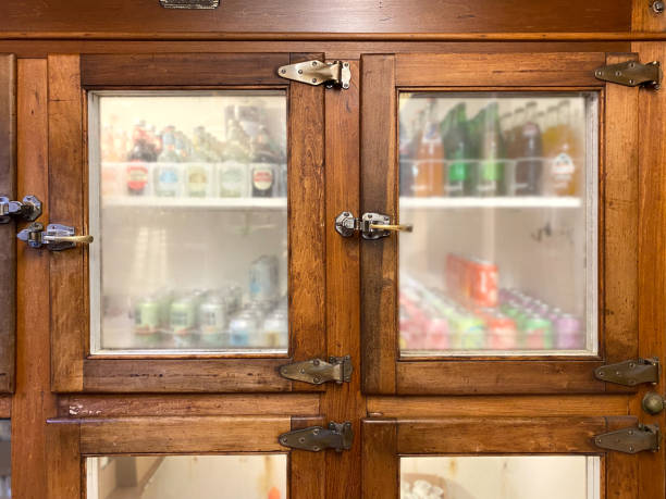 Old vintage ice box refrigerator with frosted glass windows. Soda beverages inside wood and glass doors stock photo