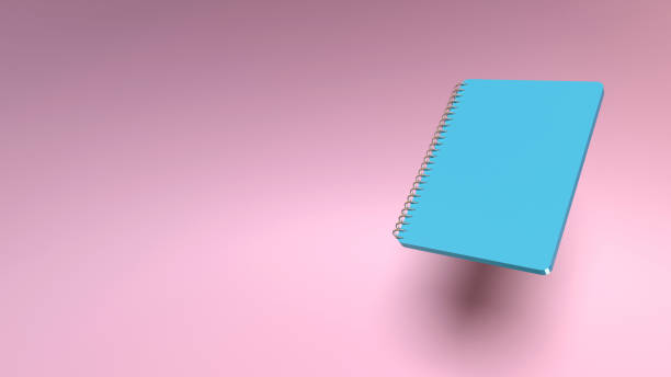 istock Back to School Concept with A Blue Hardcover Note Pad On Pink Coral Background 1410885039