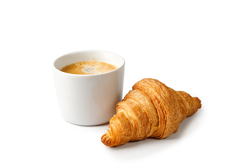 Cup of coffee and fresh baked Croissant isolated on white background. Delicious french croissant and coffee cup on a white background.