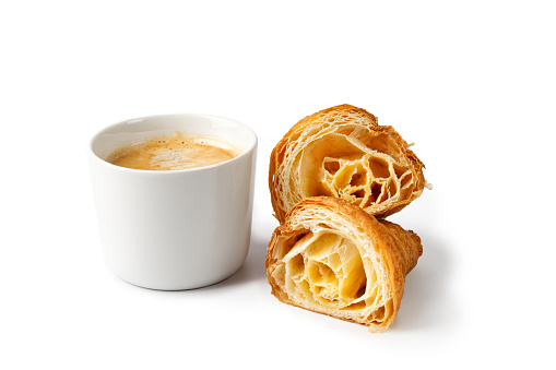 Cup of coffee and fresh baked cut in half Croissant isolated on white background. Delicious french croissant and cappuccino coffee cup.