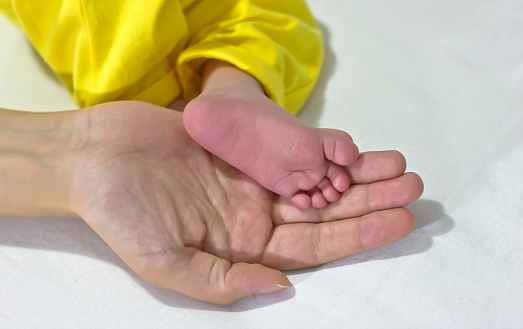 Children's tiny feet with rings on fingers