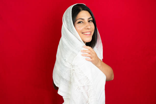 istock middle eastern woman with white scarf, red background 1410891138