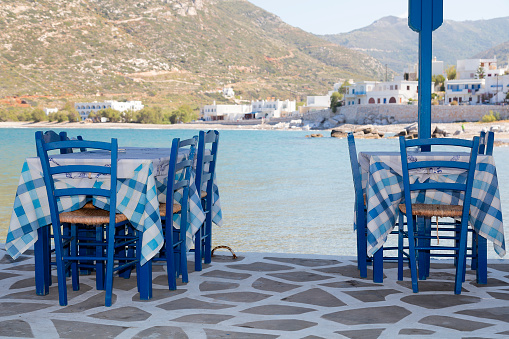 Tables and chairs in a restaurant, town of Apollonas, Naxos Island, Cyclades Islands, Aegean Sea, Greece.