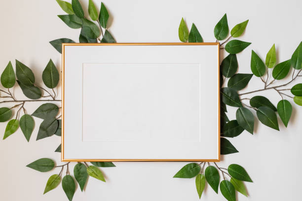 istock Mock up poster. Minimal template with empty picture frame mock up. White background with plants 1410897008