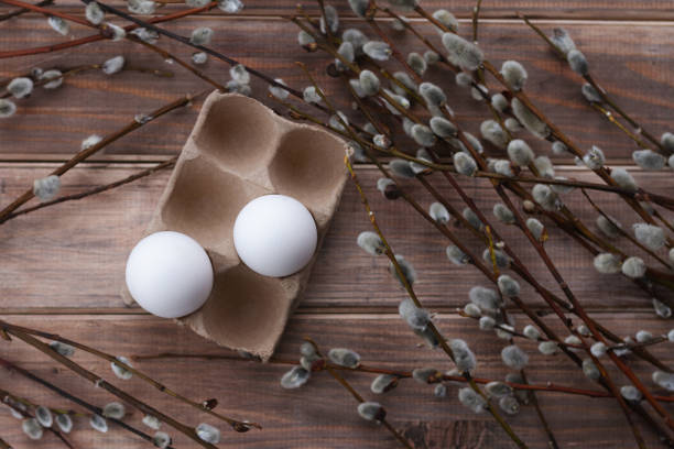 istock two white eggs in box and willow branches on wooden background 1410897755