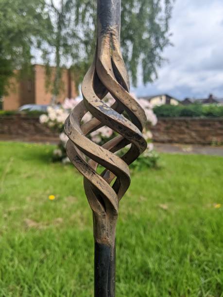 istock Spiral gate decoration in focus with a flowering bush in the blurred background 1410898097