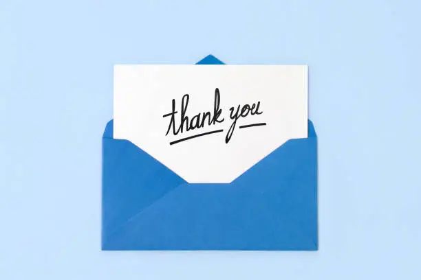 Blue envelope with thank you note on blue background