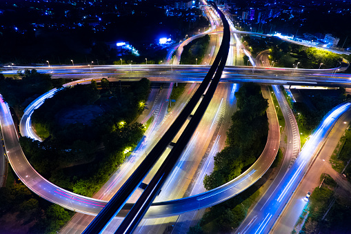 Expressway top view, Road traffic an important infrastructure,car traffic transportation above intersection road in city night, aerial view cityscape of advanced innovation, financial technology
