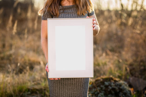 istock Mock up poster. Minimal template with empty picture frame mock up. Girl holding frame 1410899162