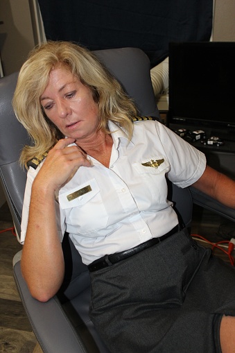 female pilot at her desk checking information and talking on the phone