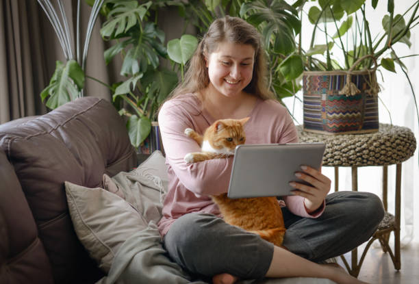 istock woman sits on a sofa  with digital tablet 1410902945