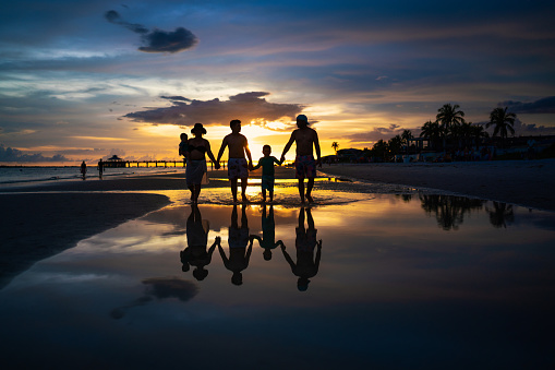 Latin family walking on the beach at sunset in Ft Myers Florida