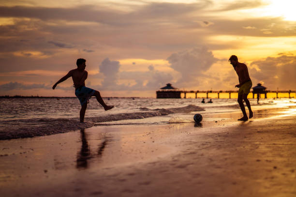Cousins Playing soccer on the beach Florida