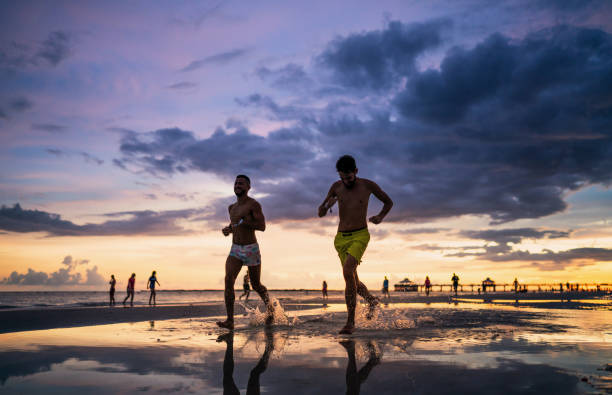 istock Young couple running on the beach in Florida 1410904819