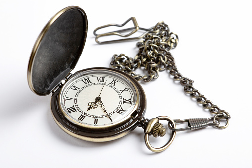 Vintage copper pocket clocks on dark wood background