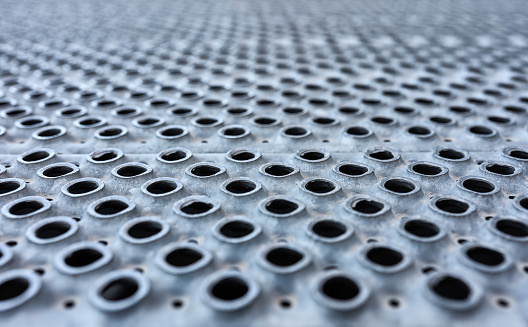 detail of a metal floor with holes to prevent slipping in the rain