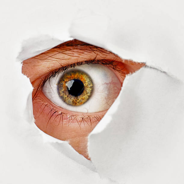 istock Eye looks through a hole in the paper - spy 141090771