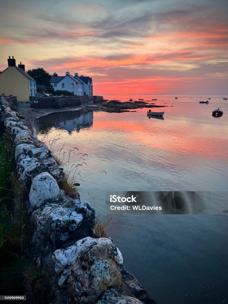 Sunset over coastal homes Sunset over houses and fishing harbor in Pembrokeshire, Wales Newport - Wales Stock Photo