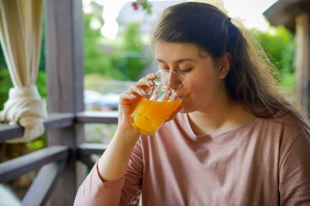 istock woman making fresh vegetable salad and drinking fresh orange juice 1410910124