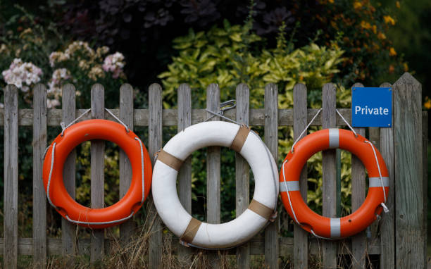 tre salvagenti pendono da una recinzione di legno - life jacket life belt buoy float foto e immagini stock
