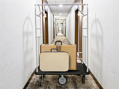 Trolley with luggage bags in front of a corridor