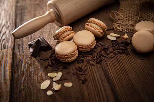 Almond and Chocolate Macaroon cookies sweet pastry on retro wood background with rolling pin