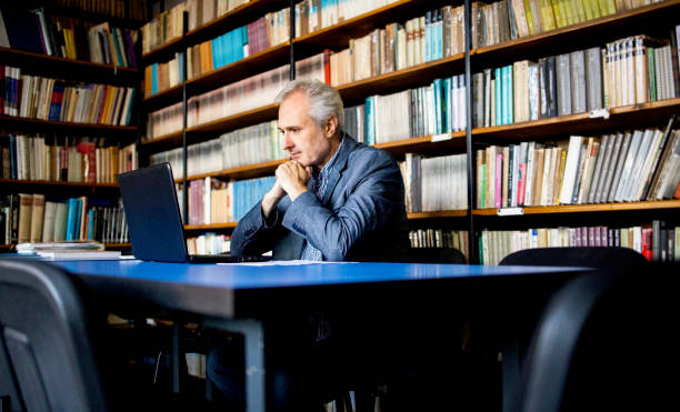 istock University professor in library looks at student statistics stock photo 1410919902