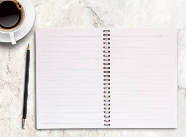 istock Top view blank notebook,pencil and coffee mug on marble background. 1410920747