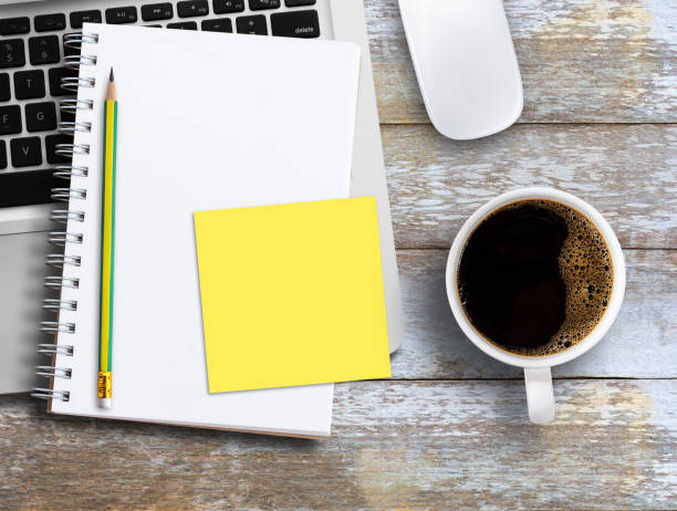 Business office desk design concept. Wood office table with cup of coffee, notebook and supplies.Top view with copy space, flat lay. Modern workspace on the desk.