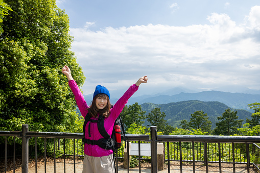 Japanese woman visiting Mt. Takao for hiking, and walking up to the peak.