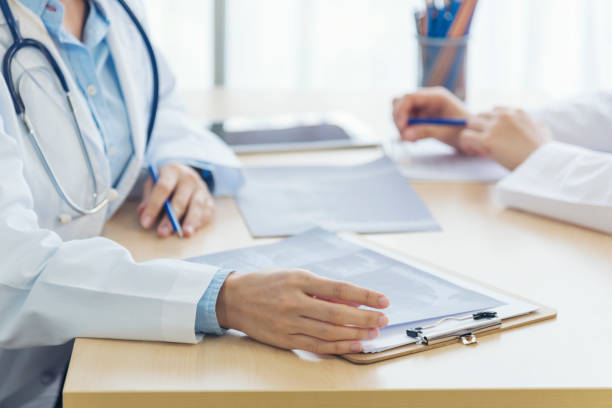 dos doctoras asiáticas discuten la reunión de la clínica médica de la oficina del doctor que mira la película de la radiografía que consulta enfermedad paciente. mujeres jóvenes de laboratorios médicos asiáticos hablando juntas sobre el trabajo en - x ray image radiologist examining using voice fotografías e imágenes de stock