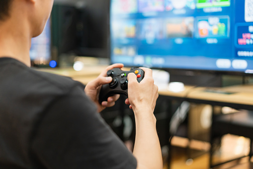Close-up of man using gamepad to play game