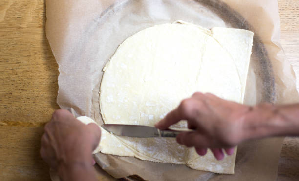 istock Hands Cutting Pastry Dough Round for Tart 1410930928