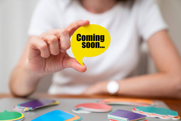 Woman wearing white t-shirt holding paper card bubble. Coming soon message on speech bubble.
