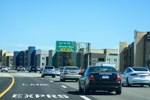 Light vehicle traffic on southbound highway 680 at Mission Boulevard. Express Lane. New modern mid-rise multi-family residential buildings along the road - Fremont, California, USA - July, 2022