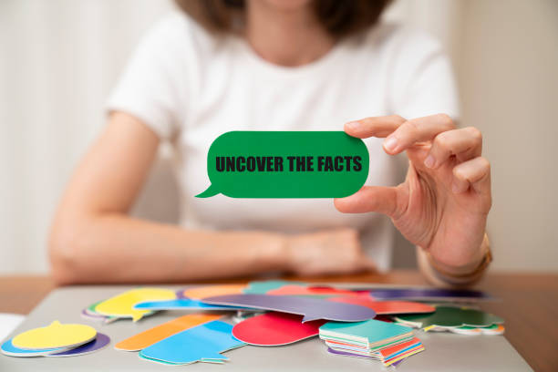 istock Woman holding speech bubble. Uncover the facts message on speech bubble. 1410934062